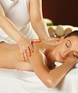 Eine Frau liegt entspannt auf einer Liege und erhält eine Rückenmassage.