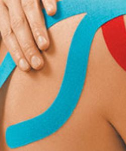Blaues und rotes Kinesio-Tape auf Schulter und Rücken, eine Hand streicht das Tape glatt.